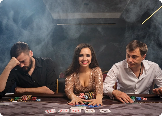 In een rokerige, schemerige pokerzaal glimlacht een vrouw in een glinsterende gouden jurk zelfverzekerd tussen twee mannen in; de ene ziet er verslagen uit, de andere peinzend.