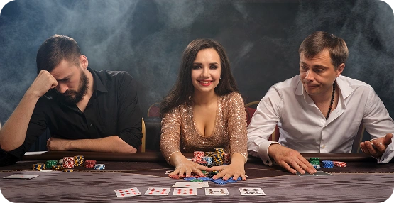 In een rokerige, schemerige pokerzaal glimlacht een vrouw in een glinsterende gouden jurk zelfverzekerd tussen twee mannen in; de ene ziet er verslagen uit, de andere peinzend.